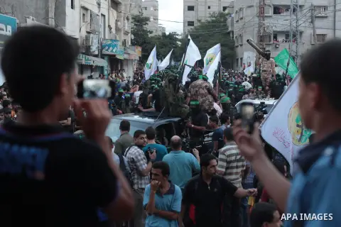 Palestinian militant members of the military Hamas wing Izz Ad-Dine Al-Qassam Brigades are seen during a march along the streets of Al Shatee refugee camp in Gaza City, 21 September 2013. Photo by Ashraf Amra