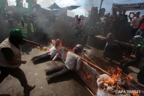 Palestinian Hamas supporters burn a mock coffin covered with an Israeli flag and effigies of Israeli President Shimon Peres during a protest to show solidarity with Al-Aqsa mosque after Friday prayers in the central Gaza...