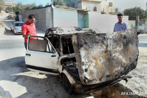 Palestinian men inspect a burnt car in the village of Burin, near the West Bank City of Nablus, 1 October 2013. According to Palestinians two cars were set on fire in a raid by Jewish settlers. Photo by Nedal Eshtayah