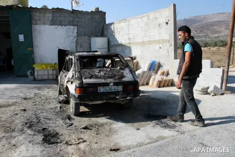 A Palestinian man inspects a burnt car in the village of Burin, near the West Bank City of Nablus, 1 October 2013. According to Palestinians two cars were set on fire in a raid by Jewish settlers. Photo by Nedal Eshtayah
