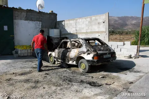 A Palestinian man inspects a burnt car in the village of Burin, near the West Bank City of Nablus, 1 October 2013. According to Palestinians two cars were set on fire in a raid by Jewish settlers. Photo by Nedal Eshtayah