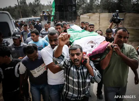 Palestinians carry the body of Heweshil Abu Heweshil, who was killed by Israeli soldiers, during his funeral in center Gaza City October 1, 2013. Israeli soldiers shot dead Abu Heweshil near the border fence between Isra...