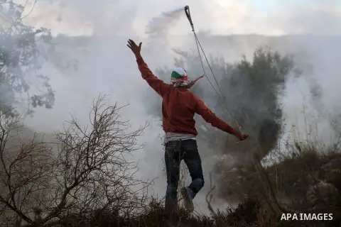 A Palestinian protester uses a sling to throw stones at Israeli soldiers during clashes near the Israeli military prison of Ofer, near the West Bank city of Ramallah October 4, 2013. Photo by Issam Rimawi