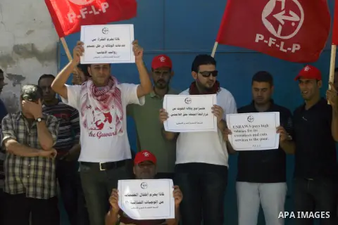 Palestinians of the Popular Front for the Liberation of Palestine (PFLP) hold banners during a protest infront of the UNRWA headquarters against the UNRWA decision Reduce aid in Rafah in the southern Gaza Strip, on Oct....
