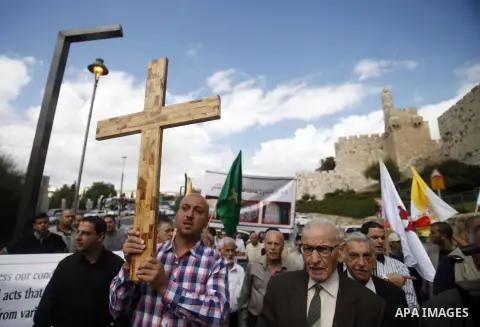 A Palestinian protester holds a cross during a demonstration against acts of vandalism on Christian sites in Israel and the occupied West Bank, outside Jerusalem's Old City October 6, 2013. Last week four suspected Jewis...