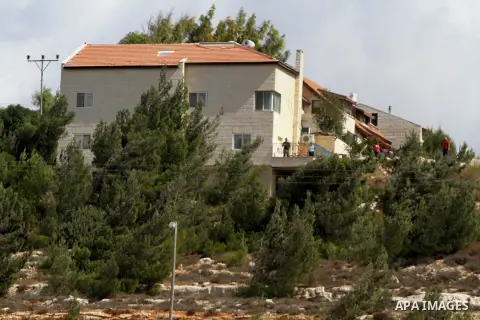 Israeli Jewish settlers stand near their house at the Jewish settlement of Psagot near the West Bank City of Ramallah. Prime Minister Benjamin Netanyahu said Sunday he holds the Palestinian Authority responsible for a su...
