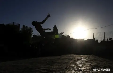 A Palestinian youth practices his parkour skills during the sunset in Jerusalem's Old City on October 08, 2013. Parkour, French slang for the art of moving, is a physical activity that maximizes the body's efficiency wit...