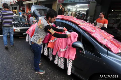 A Palestinian vendor displays clothes on a car in preparation for the upcoming Eid-al-Adha, or ''Feast of Sacrifice,'' in the West Bank City of Ramallah on October 13, 2013. Millions of Muslims around the world celebrate...
