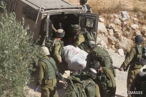 Israeli soldiers carry away the body of armed Palestinian militant Mohammed Assi near the West Bank village of Bilin, near Ramallah October 22, 2013. Israeli forces on Tuesday killed Assi, 28, who was wanted for his alle...