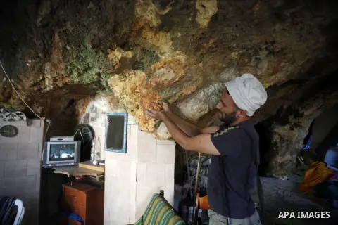 Khaled al-Zeer al-Husaini, 39, inspects his cave in the east Jerusalem Arab neighbourhood of Silwan, Oct. 22, 2013. An Israeli court demanded family Silwan to stop the restoration work inside the cave. Photo by Saeed Qaq