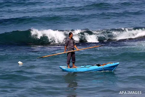 A Palestinian fisherman rides a fishing boat at the beach of Gaza City, on Oct. 23, 2013. Israel restricted the fishing zone to three nautical miles following the kidnapping of Israeli soldier Gilad Shalit in 2007. The O...