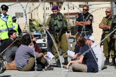 Israeli and foreign protesters argue with Israeli security forces as they protest against the arrival of thousands of Jewish visitors to the city, in the centre of the divided West Bank city of Hebron, 25 October 2013. S...
