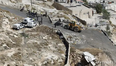 A picture taken on Oct. 28, 2013, shows a bulldozer demolishing the home of Moses Shkirat in Jabel Mukaber neighborhood southern Jerusalem. Palestinian homes built without an Israeli construction permit are often demolis...