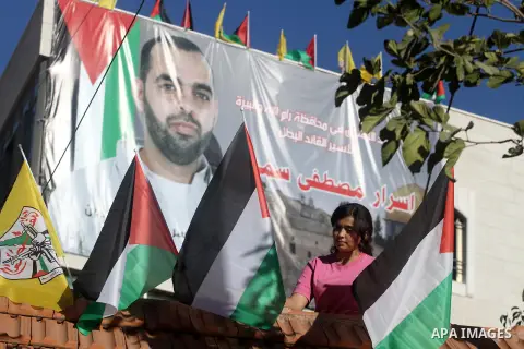 A relative of Palestinian prisoner Israr Samreen holds a flag as she celebrates after receiving the news of his impending release, in the West Bank city of Ramallah October 28, 2013. Samreen is one of 26 Palestinian pris...