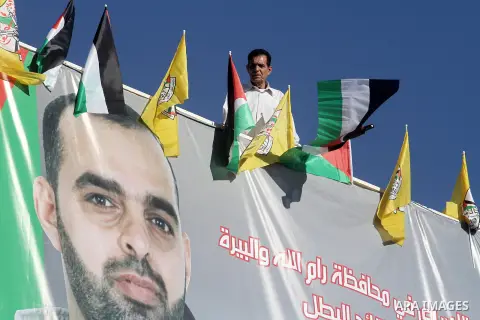 Relatives hang a banner depicting Palestinian prisoner Israr Samreen outside his house, in the West Bank city of Ramallah October 28, 2013. Samreen is one of 26 Palestinian prisoners that Israel approved on Sunday to rel...