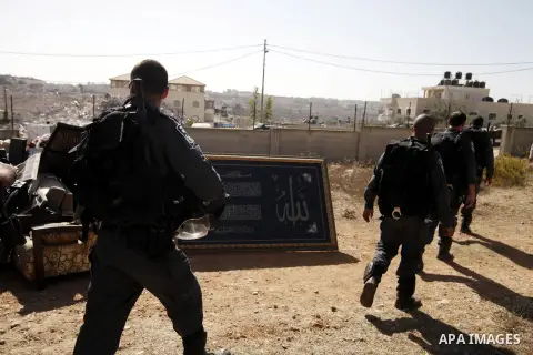 Israeli police officers stand guard as a house belonging to Palestinians is being demolished by Israeli municipality in the East Jerusalem neighbourhood of Beit Hanina, October 29, 2013. A statement from the Jerusalem Mu...