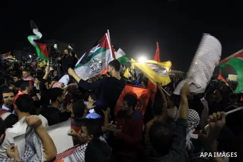 Palestinian families and friends celebrate as they gather outside the headquarters of president Mahmud Abbas for the release of some 26 prisoners from Israeli jails, in the West Bank city of Ramallah, on October 29, 2013...