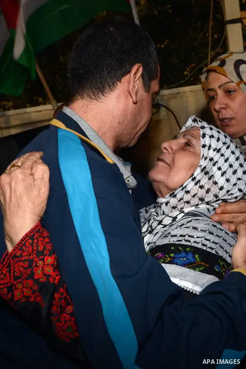 A released Palestinian prisoner is greeted by people upon his arrival outside the headquarters of Palestinian President Mahmoud Abbas, in the West Bank city of Ramallah, October 30, 2013. Israel freed 26 Palestinian pris...