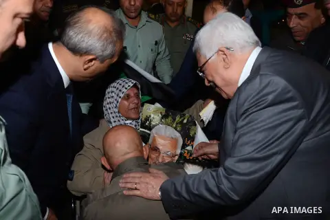 Palestinian President Mahmoud Abbas greets a released prisoner upon his arrival outside Abbas's headquarters in the West Bank city of Ramallah, October 30, 2013. Israel freed 26 Palestinian prisoners on Wednesday, the se...