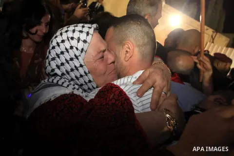 A released Palestinian prisoner coming from an Israeli jail is welcomed by his family members as he arrives at Palestinian President Mahmoud Abbas' headquarters in the West Bank town of Ramallah, West Bank, 30 October 20...