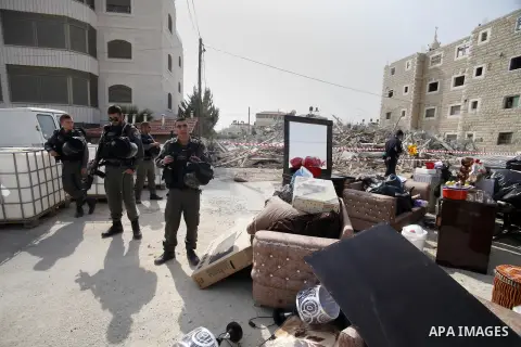 Israeli police officers stand guard as a house belonging to Palestinians is being demolished by Israeli municipality in the East Jerusalem neighbourhood of Beit Hanina, which falls in the West Bank side of Israel's separ...
