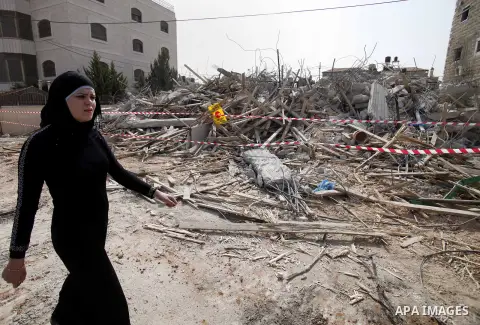 A Palestinian woman stands on the rubble after Israeli forces destroyed their family house in the East Jerusalem neighbourhood of Beit Hanina, which falls in the West Bank side of Israel's separation barrier on Oct. 30,...