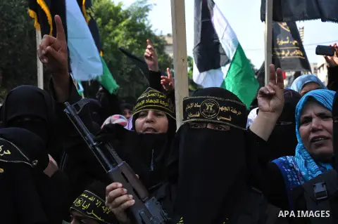 Palestinian female militants of the Islamic Jihad hold their weapons during a rally marking the 26th anniversary of the movement's foundation and marking the 18th anniversary of the death of the group's leader Fathi Shik...