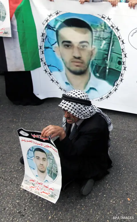 Palestinians hold pictures of their relatives prisoners in Israeli jails hold during a protest calling for release them, in the West Bank City of Ramallah, November 05, 2013. Photo by Issam Rimawi