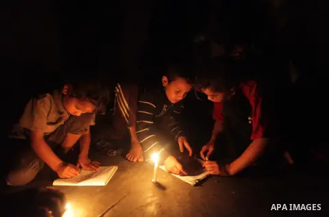 Palestinian children study on candles light during a power cut in Deir al-Balah in central Gaza Strip November 6, 2013. Gaza's lone power plant shut its generators on Friday due to a fuel shortage, a move that will likel...