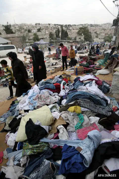 Palestinians look at second hand clothes at a public market in the West Bank City of Hebron, November 07, 2013. Due to the current economic situation in the West Bank and Gaza Strip, many of the Palestinians resort to me...
