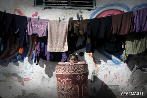 A Palestinian girl plays outside her family's home at al-Shati refugee camp, the third largest in the Palestinian Territories, in Gaza City on November 11, 2013. Photo by Ashraf Amra