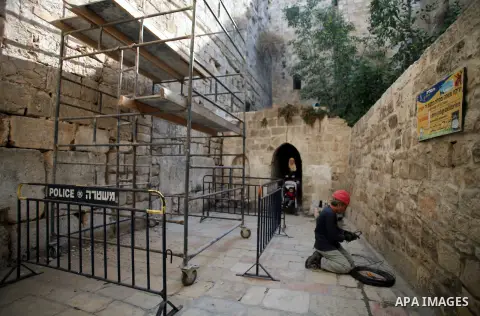 A laborer of Israeli Antiquities Authority works on a wall in entrance of Shihabi neighborhood next to the Al-Aqsa Mosque, in Jerusalem's Old City on November 11, 2013. Israeli Antiquities Authority intends to transform...