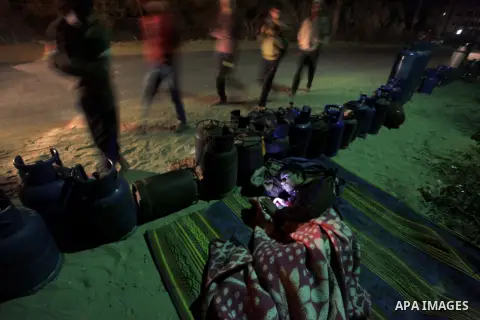 A Palestinian man sleeps near the gas canisters to fill cooking gas canisters outside a filling station at Deir al-Balah in central Gaza Strip November 12, 2013. Palestinian officials said Israel allows limited quantity...