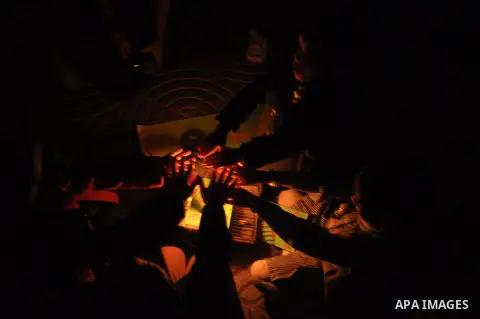 Palestinian school children warm themselves on a candle during a protest against the severe fuel cuts that lead to power shortages and the siege in Gaza City on November 12, 2013. Gaza is left dependent on electricity pu...