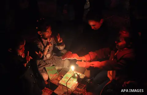 Palestinian school children warm themselves on a candle during a protest against the severe fuel cuts that lead to power shortages and the siege in Gaza City on November 12, 2013. Gaza is left dependent on electricity pu...