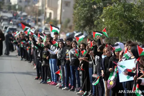 Palestinian protesters hold placards and flags during a demonstration in solidarity with Palestinian prisoners in Israeli jails, in the West Bank City of Ramallah, November 13, 2013. A human rights report said on Tuesday...