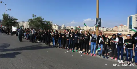 Palestinian protesters hold placards and flags during a demonstration in solidarity with Palestinian prisoners in Israeli jails, in the West Bank City of Ramallah, November 13, 2013. A human rights report said on Tuesday...