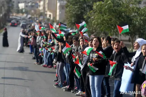 Palestinian protesters hold placards and flags during a demonstration in solidarity with Palestinian prisoners in Israeli jails, in the West Bank City of Ramallah, November 13, 2013. A human rights report said on Tuesday...