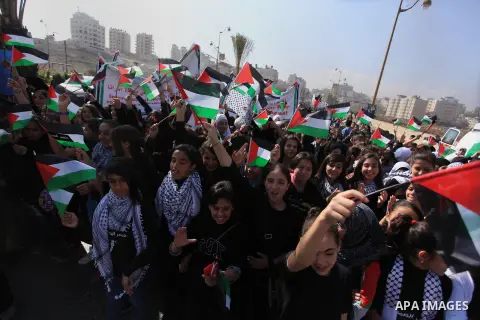 Palestinian protesters hold placards and flags during a demonstration in solidarity with Palestinian prisoners in Israeli jails, in the West Bank City of Ramallah, November 13, 2013. A human rights report said on Tuesday...