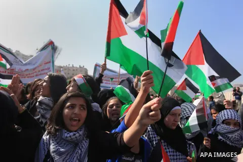 Palestinian protesters hold placards and flags during a demonstration in solidarity with Palestinian prisoners in Israeli jails, in the West Bank City of Ramallah, November 13, 2013. A human rights report said on Tuesday...