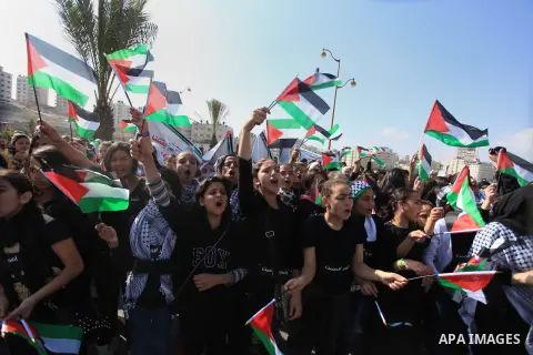 Palestinian protesters hold placards and flags during a demonstration in solidarity with Palestinian prisoners in Israeli jails, in the West Bank City of Ramallah, November 13, 2013. A human rights report said on Tuesday...