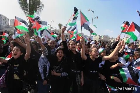 Palestinian protesters hold placards and flags during a demonstration in solidarity with Palestinian prisoners in Israeli jails, in the West Bank City of Ramallah, November 13, 2013. A human rights report said on Tuesday...
