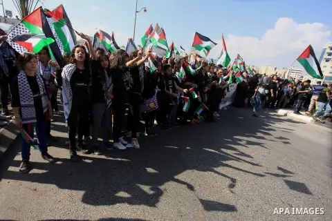 Palestinian protesters hold placards and flags during a demonstration in solidarity with Palestinian prisoners in Israeli jails, in the West Bank City of Ramallah, November 13, 2013. A human rights report said on Tuesday...