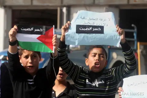 Palestinian protesters hold placards and flags during a demonstration in solidarity with Palestinian prisoners in Israeli jails, in the West Bank City of Ramallah, November 13, 2013. A human rights report said on Tuesday...