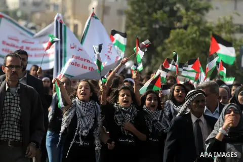 Palestinian protesters hold placards and flags during a demonstration in solidarity with Palestinian prisoners in Israeli jails, in the West Bank City of Ramallah, November 13, 2013. A human rights report said on Tuesday...