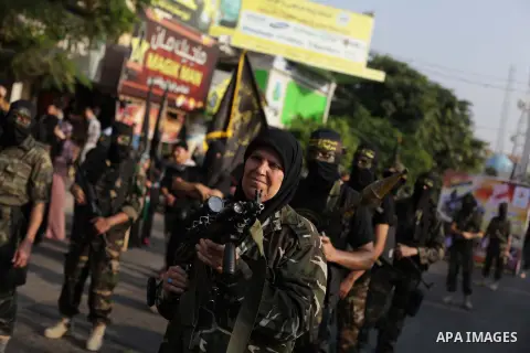 A female militant of the Palestinian Islamic Jihad movement holds a weapon during an anti-Israeli march on November 13, 2013 in the streets of Gaza City as part of the celebrations marking the first anniversary of Israel...