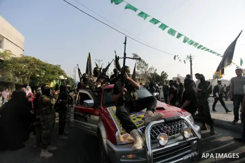 Members of the Palestinian Islamic Jihad movement parade with guns on November 13, 2013 in the streets of Gaza City during an anti-Israel march as part of the celebrations marking the first anniversary of Israel's Operat...