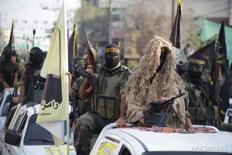 Members of the Palestinian Islamic Jihad movement parade with guns on November 13, 2013 in the streets of Gaza City during an anti-Israel march as part of the celebrations marking the first anniversary of Israel's Operat...