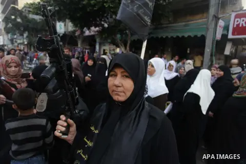 A female militant of the Palestinian Islamic Jihad movement holds a weapon during an anti-Israeli march on November 13, 2013 in the streets of Gaza City as part of the celebrations marking the first anniversary of Israel...