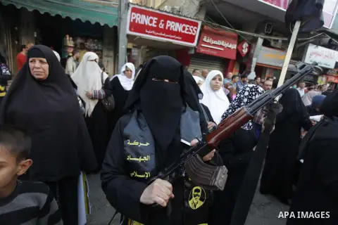 A female militant of the Palestinian Islamic Jihad movement holds a weapon during an anti-Israeli march on November 13, 2013 in the streets of Gaza City as part of the celebrations marking the first anniversary of Israel...